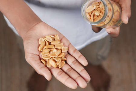 young men eating peanuts top viewの写真素材