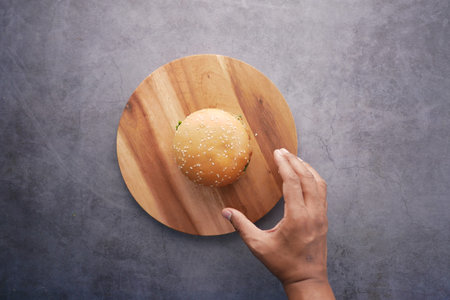 men reaching for a burger top view