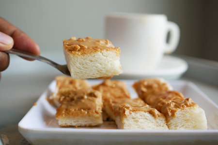 peanut butter spread on bread and cup of tea on tableの写真素材