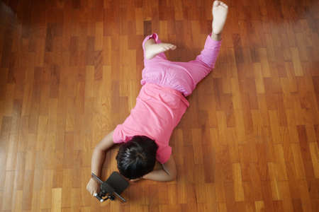 child hand pointing finger on digital tablet screen on floor top viewの写真素材