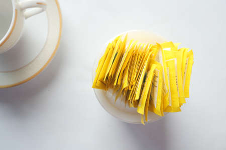 Sugar Substitute sweetener packet and tea cup on white backgroundの写真素材