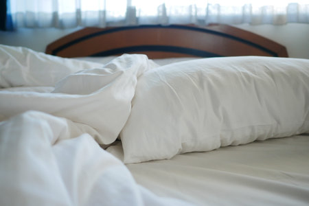 messy white bed in early morning