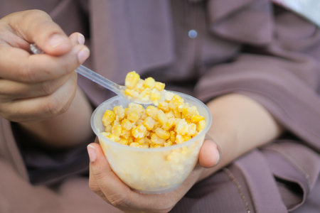 women holding a plastic bowl of organic sweet cornの写真素材