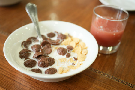 chocolate corn flakes in a bowl on tableの写真素材