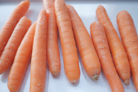 fresh carrots on chopping board on table