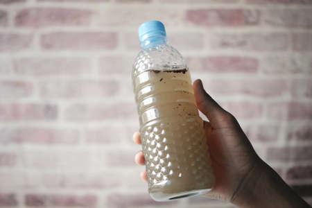 holding dirty bottle of waterの写真素材