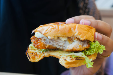 women hand holding beef burger top view