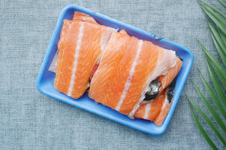 Raw, fresh salmon steak on a plastic packet on table