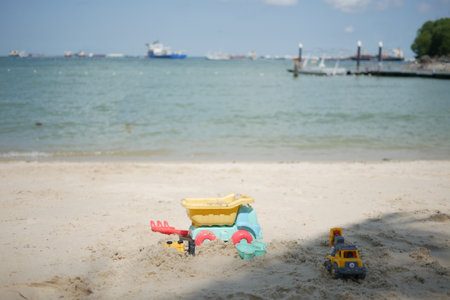 multi-colored plastic toys on a large sea sandy beachの写真素材