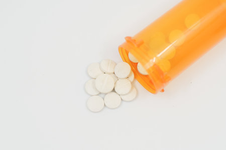 white color medical pills spilling on white backgroundの写真素材