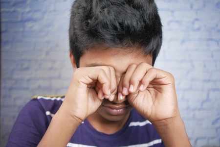 sad teenage boy crying looking down