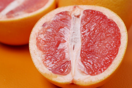 close up of slice of orange fruit on color backgroundの写真素材