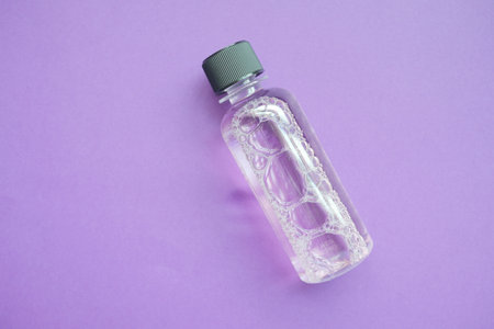 mouthwash liquid in a container on purple backgroundの写真素材