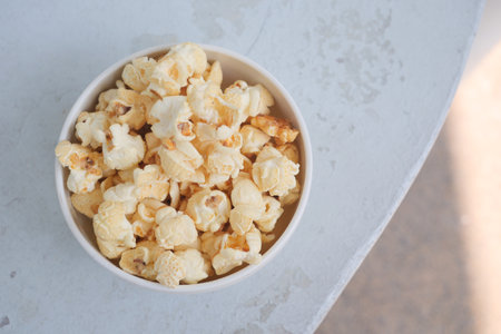 popcorn in a bowl on wooden deskの写真素材