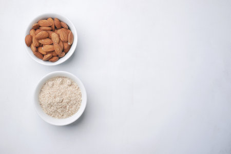almond powder and almond in a jar on white backgroundの写真素材