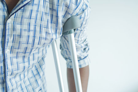 young man with broken leg on crutches.の写真素材