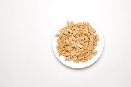 natural peanuts on a plate on white backgroundの写真素材