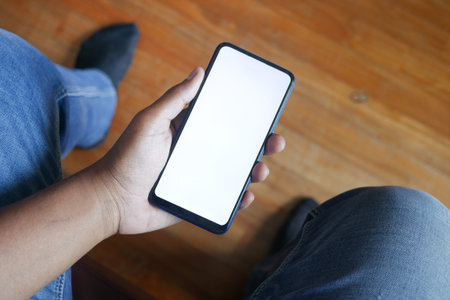 POV shot holding smart phone while sitting on chair