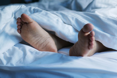 woman feet on the white bedの写真素材