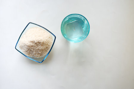 overhead view of Psyllium Seeds and glass of water on white backgroundの写真素材