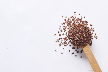 top view of flax seeds on wooden spoon on tableの写真素材