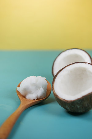 slice of fresh coconut and bottle of oil on a tableの写真素材