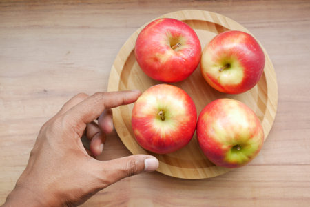 top view of hand pick fresh apple in a bowl on wooden table