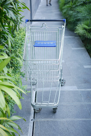 empty shopping trolley left outside of a marketの写真素材
