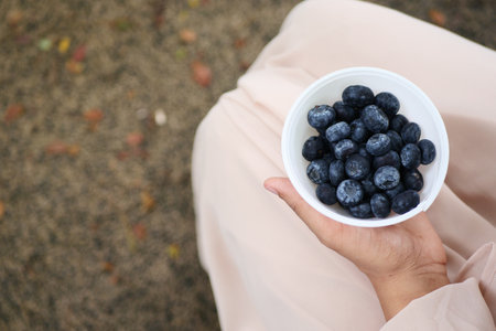 overhead view of women eating blue berry in natureの写真素材