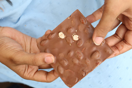 breaking peanut dark chocolate with hand