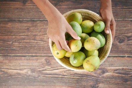 top view of hand pick fresh mango from a bowl