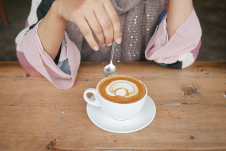 women holding a coffee cup on table