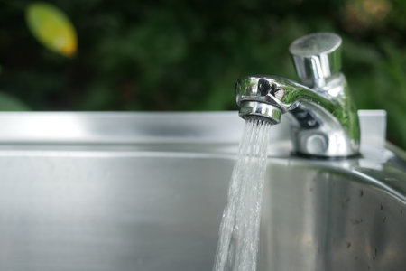 water pouring from a faucet tap slow motionの写真素材