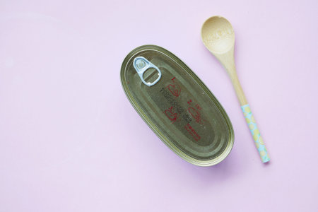open tin of sardines on white tiles background.
