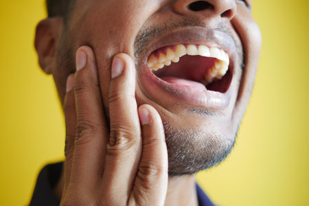 young man with sensitive teeth close upの写真素材