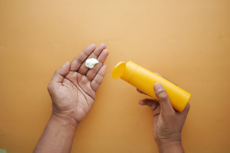 top view of person hand using sunscreen cream outdoorの写真素材