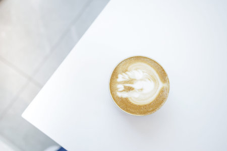 a cup of late coffee with flower shape design on top at cafe