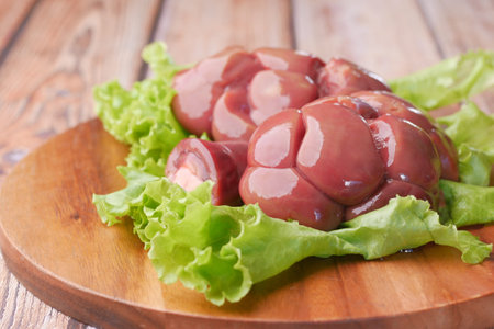 Raw fresh lamb kidneys on a chopping board