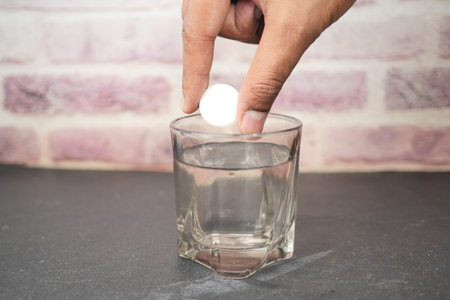 dropping Effervescent soluble tablet pills in a glass of water