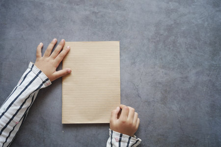 top view of child holding a empty paper on blackの写真素材