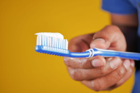 hand holding tooth brush with paste