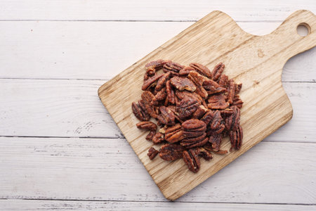 Tasty pecan-nut on a wooden board on white color table