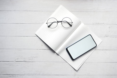 top view of smart phone and notepad on table