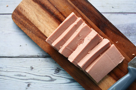 close up of cutting canned meat with a knife on tableの写真素材