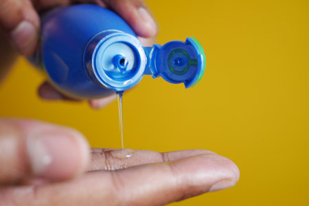 pouring hair oil on hand close upの写真素材