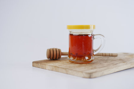 fresh honey in a glass jar isolated on whiteの写真素材