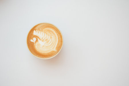 a cup of late coffee with flower shape design on top at cafeの写真素材