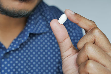 Close up of man hand holding pills with copy space