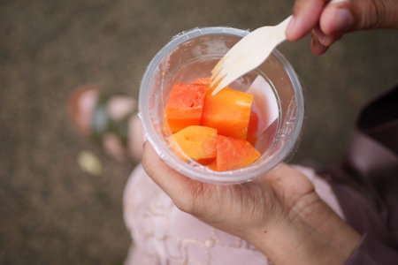 women eating papaya and grape from a plastic take away containerの写真素材