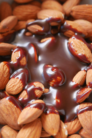 dark chocolate cream pouring on almond nut on whiteの写真素材